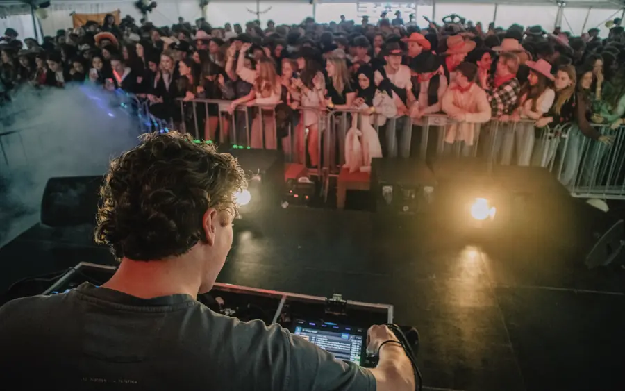 DJ achter de draaitafels voor een vol publiek